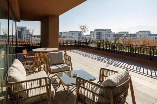 a patio with chairs and a table on a balcony at Qosmo Brasov Hotel in Braşov