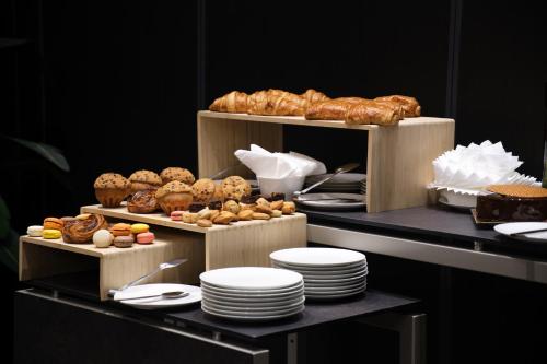 a display of pastries and breads on shelves with plates at K Hotel Douala in Douala