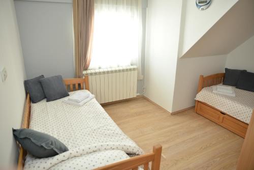 a bedroom with two beds and a window at Apartman Ema BIG 64m2-duplex Kopaonik in Kopaonik