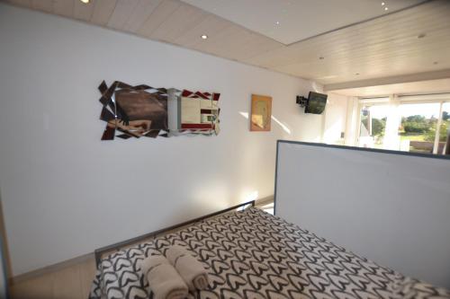 een slaapkamer met een bed en een spiegel aan de muur bij Studio Naturiste "ALCOVE" Port Nature 706 in Cap d'Agde