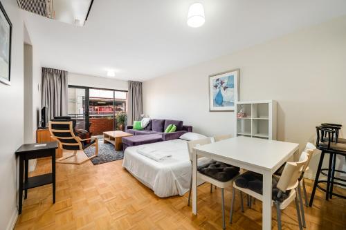 ein Wohnzimmer mit einem Bett und einem Tisch in der Unterkunft Swainson on Union in Adelaide