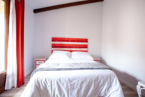 a bedroom with a bed with a red and white headboard at APARTAMENTOS LA VIEJA IMPRENTA in Sigüenza