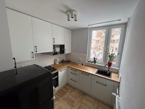 a kitchen with white cabinets and a stove top oven at Apartament Wspomnienie in Duszniki Zdrój