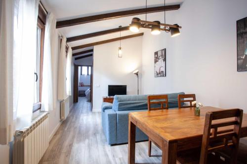 APARTAMENTOS LA VIEJA IMPRENTA في سيغوينزا: غرفة معيشة مع أريكة زرقاء وطاولة