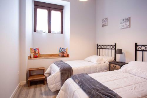 a bedroom with two beds and a window at APARTAMENTOS LA VIEJA IMPRENTA in Sigüenza