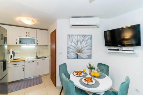 a kitchen and dining room with a table and chairs at Holiday Home Kazerma in Dubrovnik