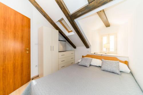 a bedroom with a large bed and a wooden door at Holiday Home Kazerma in Dubrovnik
