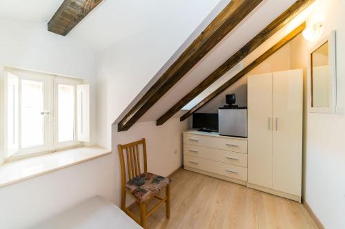 a room with a bed and a chair and a window at Holiday Home Kazerma in Dubrovnik