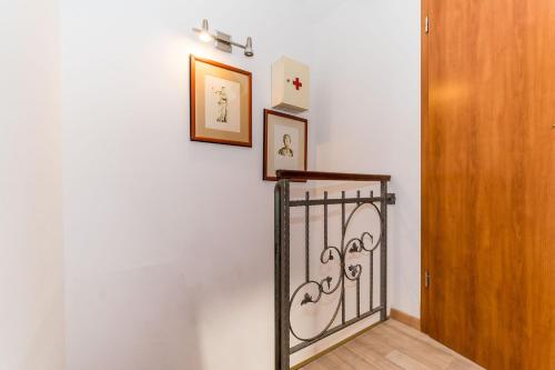 a hallway with a gate and two pictures on a wall at Holiday Home Kazerma in Dubrovnik