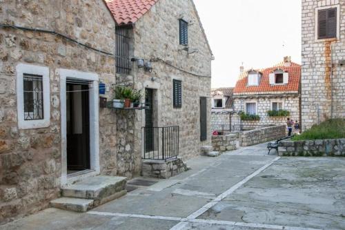 an old stone building with a door and a courtyard at Holiday Home Kazerma in Dubrovnik