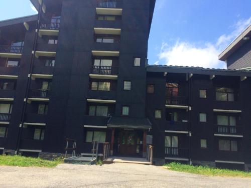 un immeuble noir avec la porte d'entrée ouverte dans l'établissement Studio cosy avec vue sur la montagne - Les Belleville - 20 m², aux Menuires