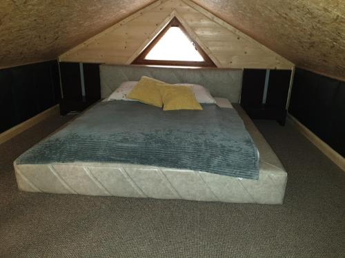 a large bed in a attic with a window at Izba w centrum miasta in Zakopane