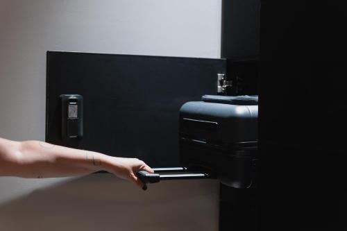 a persons hand presses a button on a paper towel dispenser at ISLA Tel Aviv in Tel Aviv