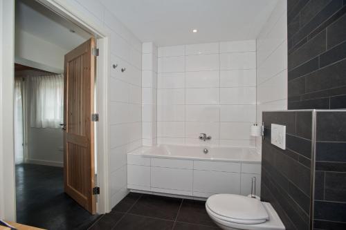 a bathroom with a tub and a toilet and a sink at Bed & Breakfast Notterveld in Notter