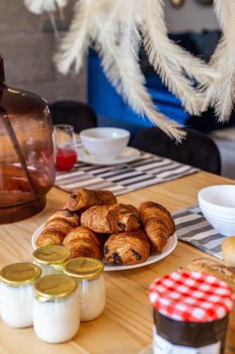 a table with a plate of croissants and other pastries at Luxury Apartments Jardins d'ARLIAS by Sweett in Cannes