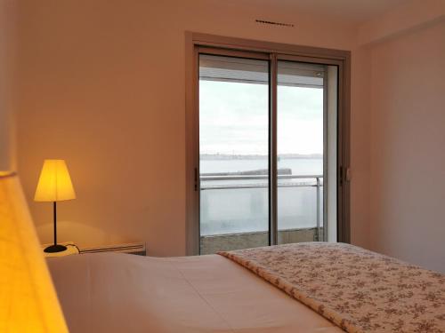 1 dormitorio con cama y ventana grande en Brise Lame en Les Sables-dʼOlonne