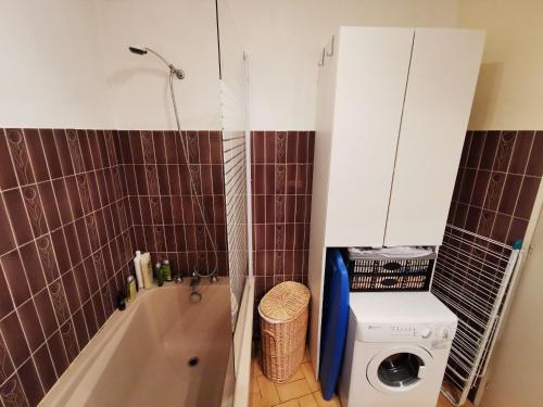 une salle de bain avec baignoire et machine à laver dans l'établissement Brise Lame, à Les Sables-dʼOlonne