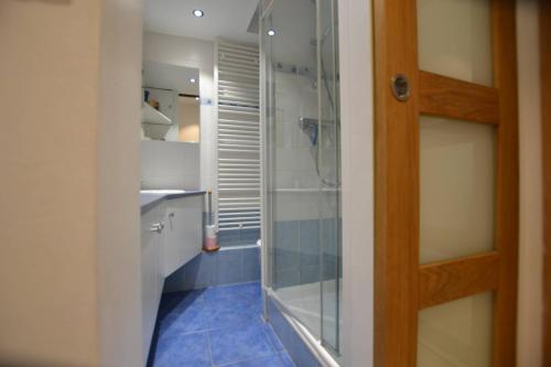 une salle de bain avec une douche à l'italienne et une porte vitrée dans l'établissement Studio Naturiste 