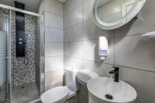 a bathroom with a toilet and a sink and a mirror at Rigas Hotel Skopelos in Skopelos Town