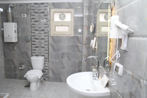 a bathroom with a toilet and a sink at Jewel Agouza Hotel in Cairo