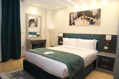 a bedroom with a large bed with a green headboard at Jewel Agouza Hotel in Cairo