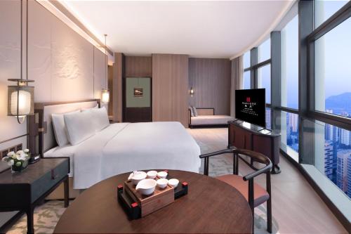 a hotel room with a bed and a table at HUALUXE Hotels and Resorts Qingdao Licang in Qingdao