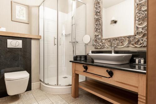 a bathroom with a toilet a sink and a bathtub at Aries Hotel & SPA Zakopane in Zakopane