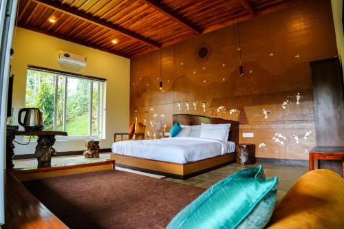 a bedroom with a bed and a large window at Ananterra Resort Wayanad in Wayanad