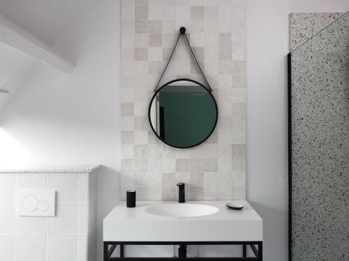 a bathroom with a white sink and a mirror at La Petite Histoire gîtes-appartements in Ath