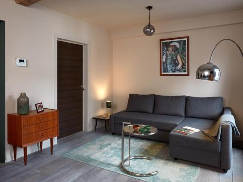 a living room with a couch and a table at La Petite Histoire gîtes-appartements in Ath