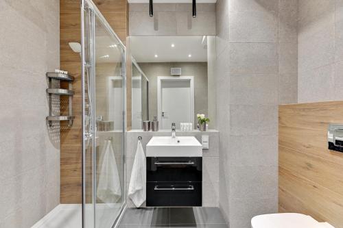 a bathroom with a sink and a shower at Baltica Panorma View by TriApart in Gdańsk