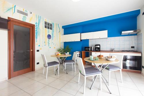 a kitchen with blue walls and a table and chairs at Ogliastra Apartment Rooms in Cagliari