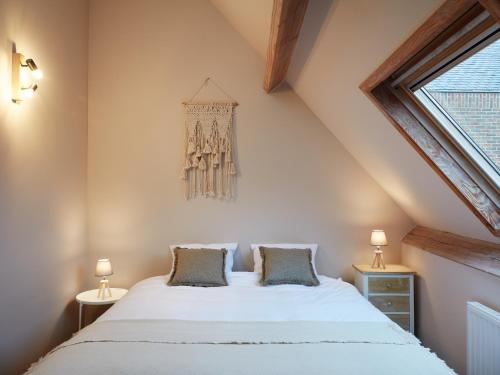 - une chambre avec un grand lit blanc et deux lampes dans l'établissement La Petite Histoire gîtes-appartements, à Ath