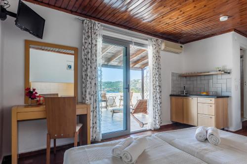 um quarto com uma cama, uma secretária e uma cozinha em Argo Pension em Skiathos