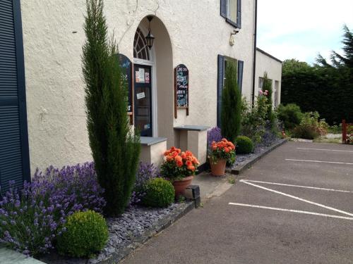 un bâtiment avec des fleurs et des plantes dans un parking dans l'établissement Castle Lodge Wilton, à Ross-on-Wye