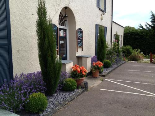 a building with flowers and plants in a parking lot at Castle Lodge Wilton in Ross on Wye