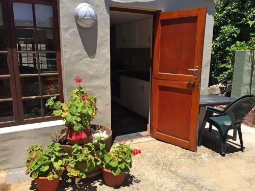 a door and two potted plants in front of a house at 8 On Main in Witsand