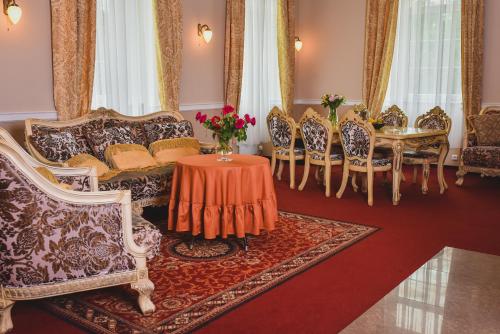 a living room with a couch and a table and chairs at Zámek Kamenný Dvůr in Kynšperk nad Ohří
