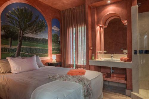 a bedroom with a bed and a bathroom with a sink at Villa Orquidea in Benalup Casas Viejas