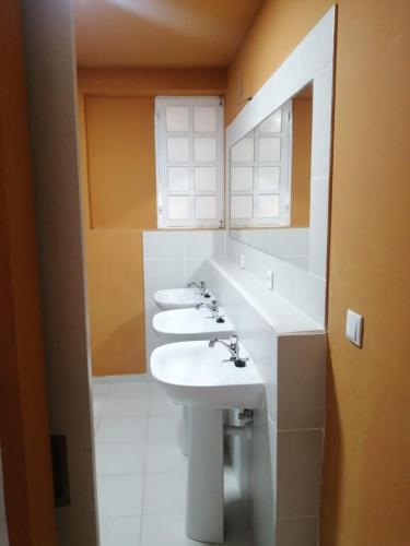 a bathroom with two sinks and a mirror at Surf House Hostel in Santa Maria
