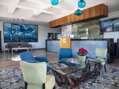a meeting room with a glass table and blue chairs at Sawari Hotel in San Carlos