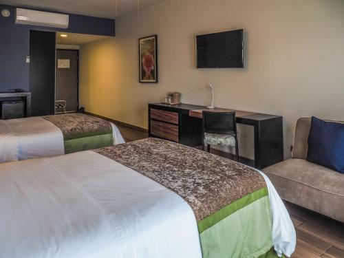 a hotel room with two beds and a couch at Sawari Hotel in San Carlos