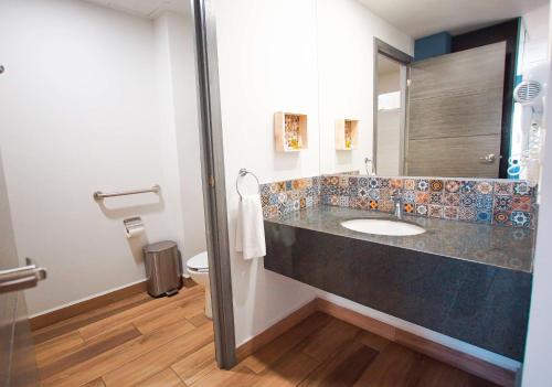 a bathroom with a sink and a toilet at Sawari Hotel in San Carlos