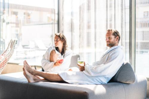 a man and a woman sitting on a couch at aja Garmisch-Partenkirchen in Garmisch-Partenkirchen