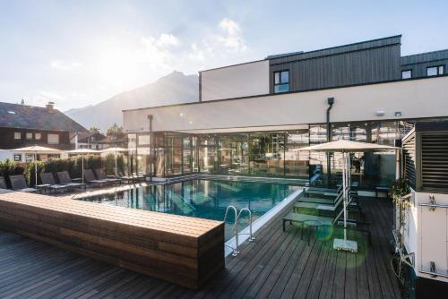 een groot gebouw met een zwembad en een terras bij aja Garmisch-Partenkirchen in Garmisch-Partenkirchen