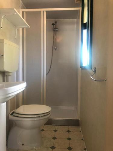 a white bathroom with a toilet and a shower at Toskana-Viareggio-Chalet-Zona-Rosa-1-mit-Klimaanlage-und-Wlan in Viareggio