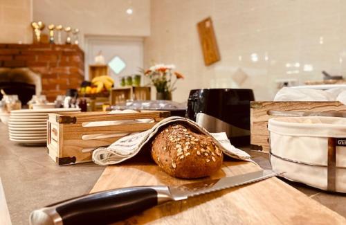 a loaf of bread sitting on a counter with a knife at Zelena Oaza in Zgornja Kungota