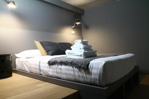 una camera da letto con letto, lenzuola e cuscini bianchi di Dimore al Te a Mantova