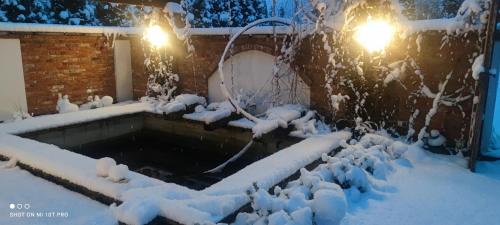 a swimming pool covered in snow at night at Noclegi Szymrych in Chełmsko Śląskie