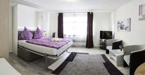 a bedroom with a purple bed and a living room at Apart-2-OG-Nr1 in Darmstadt